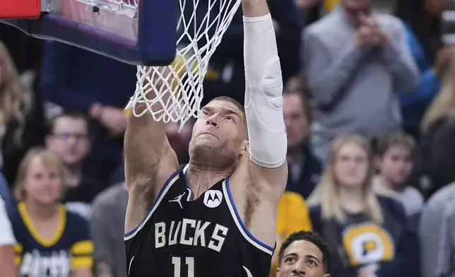 Milwaukee Bucks center Brook Lopez (11) gets a dunk in front of Indiana Pacers guard Tyrese Haliburton (0) during the first half of a first-round NBA basketball playoff game in Indianapolis, Tuesday, April 22, 2025. (AP Photo/Michael Conroy)