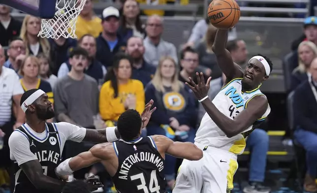 Indiana Pacers forward Pascal Siakam (43) makes a pass over Milwaukee Bucks forward Giannis Antetokounmpo (34) during the second half of a first-round NBA basketball playoff game in Indianapolis, Tuesday, April 22, 2025. (AP Photo/Michael Conroy)