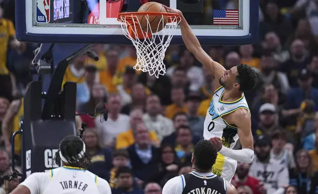 Indiana Pacers guard Tyrese Haliburton (0) gets a basket on a dunk against the Milwaukee Bucks during the first half of a first-round NBA basketball playoff game in Indianapolis, Tuesday, April 22, 2025. (AP Photo/Michael Conroy)