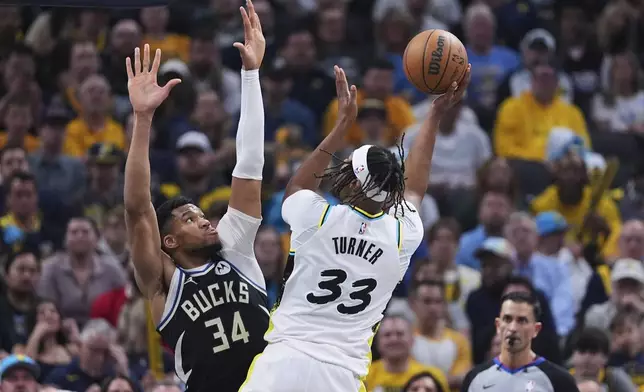 Indiana Pacers center Myles Turner (33) shoots over Milwaukee Bucks forward Giannis Antetokounmpo (34) during the first half of a first-round NBA basketball playoff game in Indianapolis, Tuesday, April 22, 2025. (AP Photo/Michael Conroy)