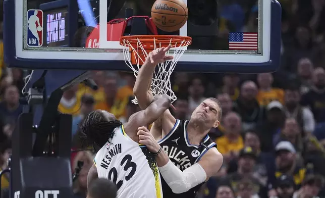 Milwaukee Bucks center Brook Lopez (11) fouls Indiana Pacers forward Aaron Nesmith (23) as he shoots during the first half of a first-round NBA basketball playoff game in Indianapolis, Tuesday, April 22, 2025. (AP Photo/Michael Conroy)