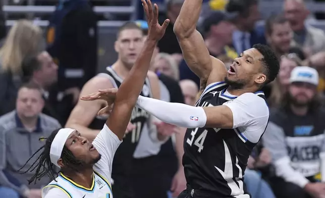 Milwaukee Bucks forward Giannis Antetokounmpo (34) shoots over Indiana Pacers center Myles Turner (33) during the first half of a first-round NBA basketball playoff game in Indianapolis, Tuesday, April 22, 2025. (AP Photo/Michael Conroy)