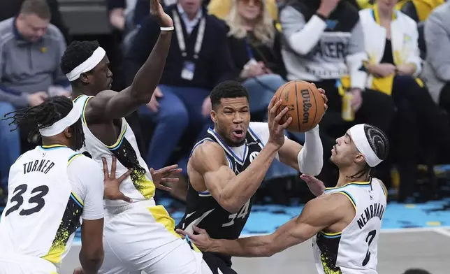 Milwaukee Bucks forward Giannis Antetokounmpo (34) is trapped by Indiana Pacers forward Pascal Siakam (43) and guard Andrew Nembhard (2) during the first half of a first-round NBA basketball playoff game in Indianapolis, Tuesday, April 22, 2025. (AP Photo/Michael Conroy)