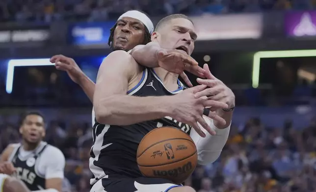 Milwaukee Bucks center Brook Lopez (11) and Indiana Pacers center Myles Turner (33) fight for a rebound during the first half of a first-round NBA basketball playoff game in Indianapolis, Tuesday, April 22, 2025. (AP Photo/Michael Conroy)
