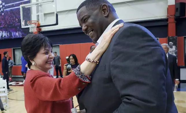 Joe Dumars, the New Orleans Pelicans executive vice president of basketball operations, is hugged by Gayle Beson, the governor of the Pelicans and owner of the NFL New Orleans Saints, after he spoke at his introductory press conference in Metairie, La., Tuesday, April 22, 2025. (AP Photo/Matthew Hinton)