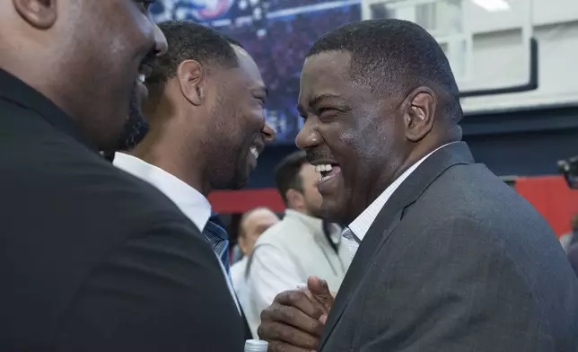 Joe Dumars, right, the New Orleans Pelicans new executive vice president of basketball operations, greets head coach Willie Green, center, next to Jordan Dumars, left, Joe Dumars' son, after his introductory NBA basetball press conference in Metairie, Tuesday, April 22, 2025. (AP Photo/Matthew Hinton)