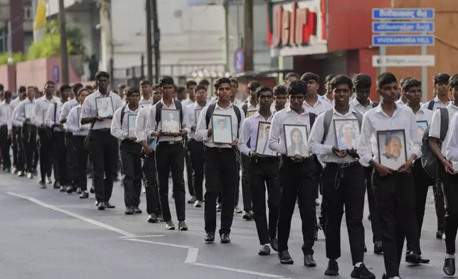 Sri Lankan Catholics walk carrying portraits of the victims of the 2019 Easter Sunday attacks during its sixth anniversary commemoration in Colombo, Sri Lanka, Monday, April 21, 2025. (AP Photo/Eranga Jayawardena)