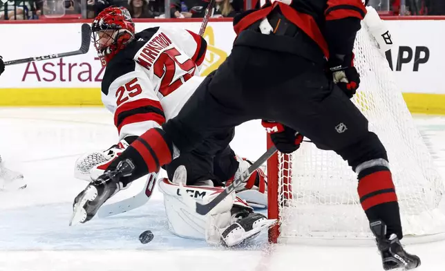 New Jersey Devils goaltender Jacob Markstrom (25) blocks a shot of the Carolina Hurricanes during the second period of Game 1 of an NHL hockey Stanley Cup first-round playoff series in Raleigh, N.C., Sunday, April 20, 2025. (AP Photo/Karl DeBlaker)