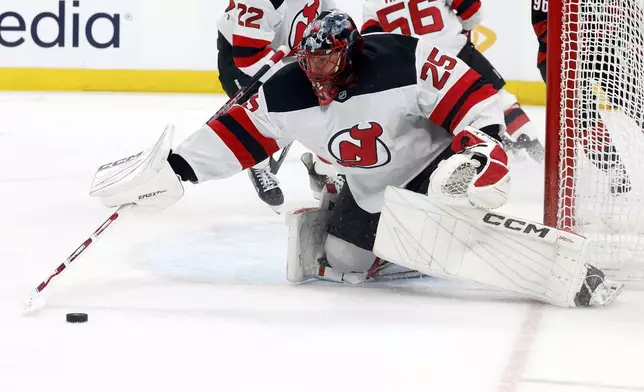 New Jersey Devils goaltender Jacob Markstrom (25) gathers in the puck against the Carolina Hurricanes during the second period of Game 1 of an NHL hockey Stanley Cup first-round playoff series in Raleigh, N.C., Sunday, April 20, 2025. (AP Photo/Karl DeBlaker)