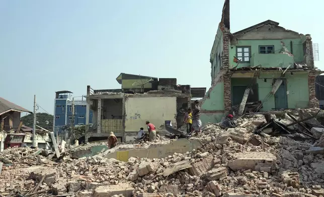 Volunteers help to clear collapsed buildings after one month of the strong earthquake in Naypyitaw, Myanmar, Monday, April 28, 2025. (AP Photo/Aung Shine Oo)