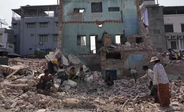 Volunteers help to clear debris of a collapsed building after one month of the strong earthquake in Naypyitaw, Myanmar, Monday, April 28, 2025. (AP Photo/Aung Shine Oo)