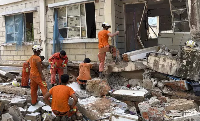 Firefighters recover the belongings of victims of the earthquake from damaged buildings that house Governments' servants in Naypyitaw, Myanmar, Monday, April 28, 2025. (AP Photo/Aung Shine Oo)