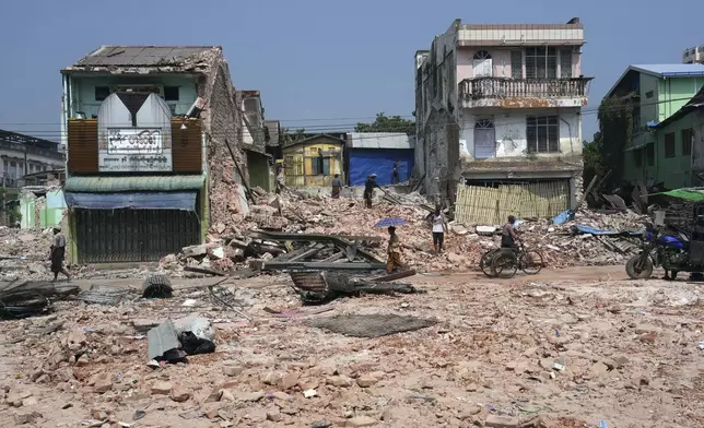 Volunteers help to clear a collapsed building after one month of the strong earthquake, in Naypyitaw, Myanmar, Monday, April 28, 2025. (AP Photo/Aung Shine Oo)