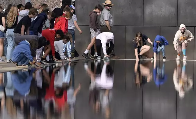 Visitors touch the Reacting Pond at the Oklahoma City National Memorial &amp; Museum in Oklahoma City on March 12, 2025. (AP Photo/LM Otero)