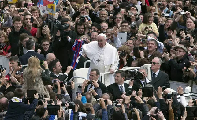 FILE - Pope Francis holds a San Lorenzo soccer jersey after celebrating his first Easter Mass in St. Peter's Square at the Vatican, March 31, 2013. (AP Photo/Alessandra Tarantino, File)