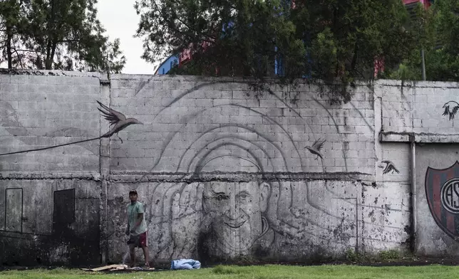 FILE - A man stands in front of a mural of Pope Francis outside the stadium of San Lorenzo, his soccer team, in the Padre Ricciardelli neighborhood of Buenos Aires, Argentina, Feb. 25, 2025. (AP Photo/Rodrigo Abd, File)