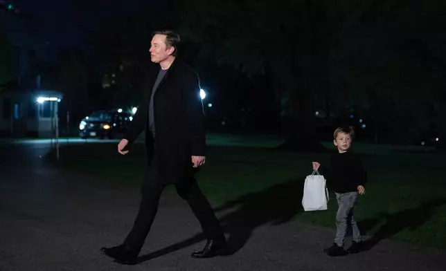 Elon Musk and his son X Æ A-Xii walk on the South Lawn upon their arrival to the White House in Washington, Sunday, April 13, 2025. (AP Photo/Jose Luis Magana)