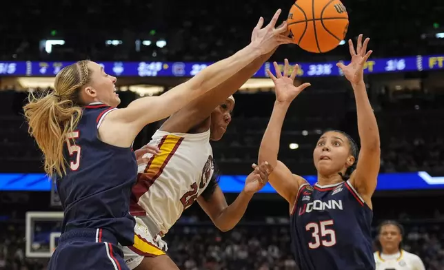 South Carolina guard Raven Johnson (25) is double teamed by UConn guard Paige Bueckers (5) and guard Azzi Fudd (35) during the first half of the national championship game at the Final Four of the women's NCAA college basketball tournament, Sunday, April 6, 2025, in Tampa, Fla. (AP Photo/John Raoux)