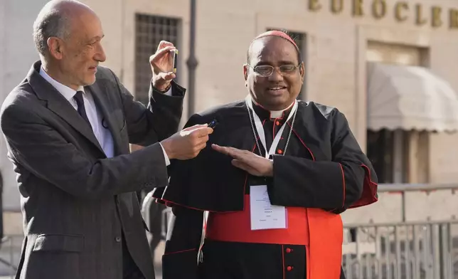 Indian Cardinal Antony Poola, right, is approached by a reporter as he arrives for a college of cardinals' meeting, at the Vatican, Wednesday, April 30, 2025. (AP Photo/Gregorio Borgia)