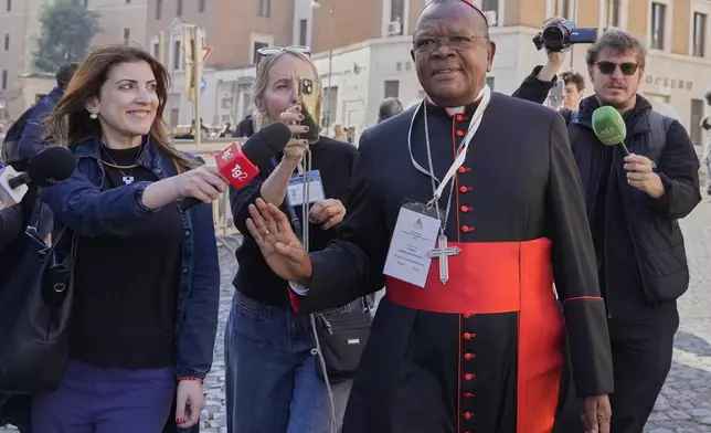 Cardinal Fridolin Ambongo Besungu is approached by reporters as he arrives for a college of cardinals' meeting, at the Vatican, Wednesday, April 30, 2025. (AP Photo/Gregorio Borgia)