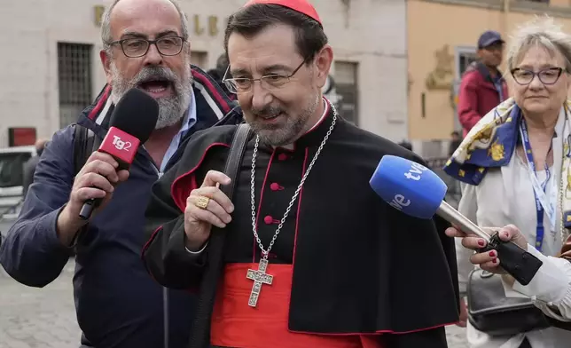 Cardinal José Cobo Cano is approached by reporters as he arrives for a college of cardinals' meeting, at the Vatican, Monday, April 28, 2025. (AP Photo/Gregorio Borgia)