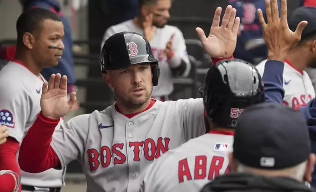 Boston Red Sox's Alex Bregman celebrates with teammates after scoring on a two-run double by Boston Red Sox's Trevor Story during the sixth inning of a baseball game against the Chicago White Sox in Chicago, Sunday, April 13, 2025. (AP Photo/Nam Y. Huh)