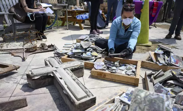 Joey Hargrove sorts through debris during a Cross Walk event by the Community United Methodist Church of the Pacific Palisades, Friday, April 18, 2025, in the Pacific Palisades area of Los Angeles. (AP Photo/William Liang)