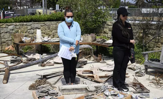 Members of a church listen to a prayer during a Cross Walk event by the Community United Methodist Church of the Pacific Palisades, Friday, April 18, 2025, in the Pacific Palisades area of Los Angeles. (AP Photo/William Liang)
