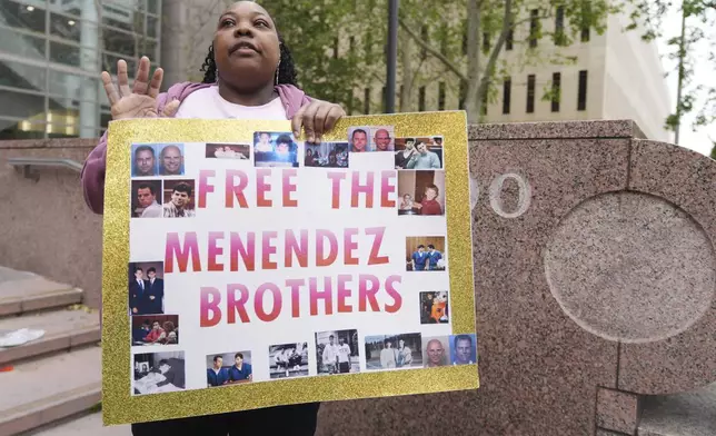 A supporter holds a sign outside of court before a hearing in the case of Erik and Lyle Menendez Thursday, April 17, 2025, in Los Angeles. (AP Photo/Damian Dovarganes)