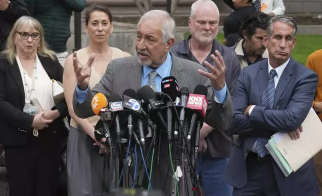 Attorney Mark Geragos, center, representing Erik and Lyle Menendez, who were sentenced in 1996 to life in prison without the possibility of parole for fatally shooting their parents, speaks to the media outside of court after a resentencing hearing in their case, Thursday, April 17, 2025, in Los Angeles. (AP Photo/Damian Dovarganes)