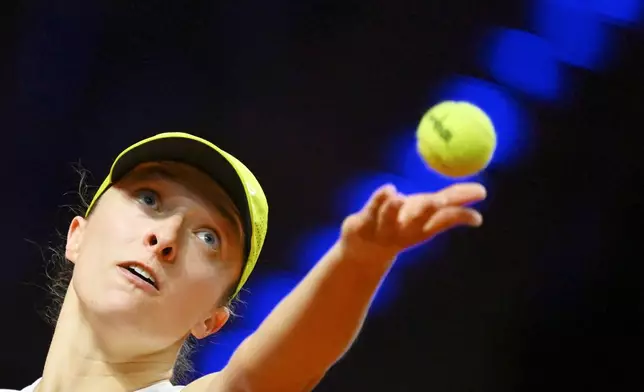 Poland's Iga Swiatek in action against Lithuania's Jelena Ostapenko during their women's singles quarterfinal tennis match at the WTA tour in Stuttgart, Germany, Saturday, April 19, 2025. (Marijan Murat/dpa via AP)