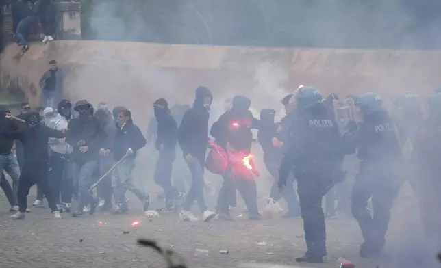 Lazio fans clash with Italian Policemen in riot gears outside the olympic stadium prior to the start of the Italian soccer match between Lazio and Roma in Rome, Sunday, April 13, 2025. (AP Photo/Gregorio Borgia)