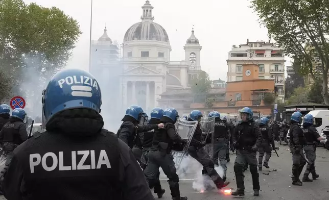 Lazio fans clash with Italian Policemen in riot gear outside the olympic stadium prior to the start of the Italian Serie A soccer match between Lazio and Roma in Rome, Sunday, April 13, 2025. (AP Photo/Gregorio Borgia)