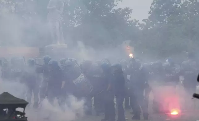 Lazio fans clash with Italian Policemen in riot gear outside the olympic stadium prior to the start of the Italian Serie A soccer match between Lazio and Roma in Rome, Sunday, April 13, 2025. (AP Photo/Gregorio Borgia)