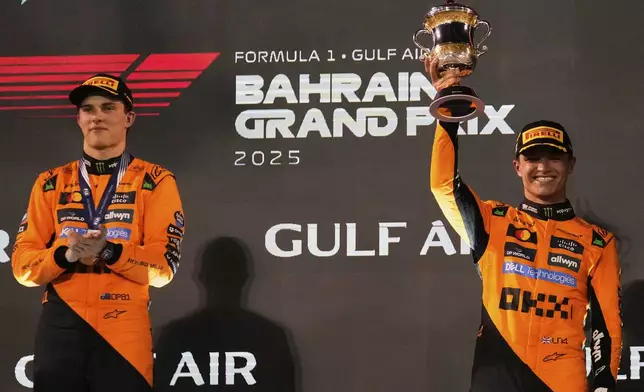 First-placed McLaren driver Oscar Piastri of Australia, left and third-placed McLaren driver Lando Norris of Britain stand on the podium the the Formula One Bahrain Grand Prix, in Sakhir, Sunday, April 13, 2025. (AP Photo/Altaf Qadri)