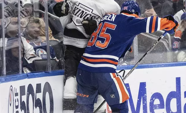 Los Angeles Kings' Samuel Helenius (79) is checked by Edmonton Oilers' Cam Dineen (85) during the third period of an NHL hockey game in Edmonton, Alberta, Monday, April 14, 2025. (Jason Franson/The Canadian Press via AP)