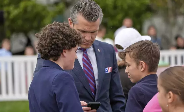 Defense Secretary Pete Hegseth looks at his phone on the South Lawn of the White House before President Donald Trump and first lady Melania Trump participate in the White House Easter Egg Roll Monday, April 21, 2025, in Washington. (AP Photo/Alex Brandon)