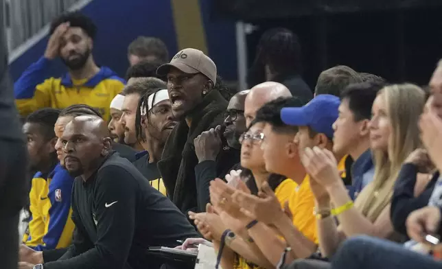Injured Golden State Warriors forward Jimmy Butler III, middle, reacts from the bench during the first half of Game 3 of an NBA basketball first-round playoff series against the Houston Rockets in San Francisco, Saturday, April 26, 2025. (AP Photo/Jeff Chiu)
