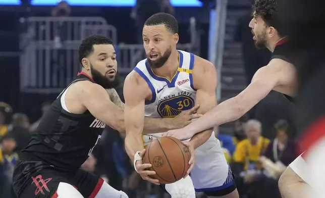 Golden State Warriors guard Stephen Curry (30) looks to pass the ball while being defended by Houston Rockets guard Fred VanVleet, left, and center Alperen Sengun during the first half of Game 3 of an NBA basketball first-round playoff series in San Francisco, Saturday, April 26, 2025. (AP Photo/Jeff Chiu)