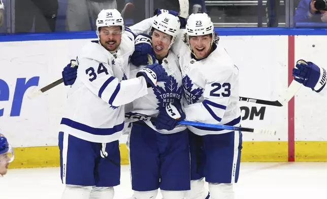 Toronto Maple Leafs right wing Mitch Marner (16) celebrates his goal with center Auston Matthews (34) and left wing Matthew Knies (23) during the third period of an NHL hockey game against the Buffalo Sabres, Tuesday, April 15, 2025, in Buffalo, N.Y. (AP Photo/Jeffrey T. Barnes)