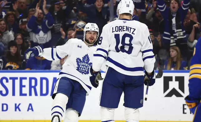 Toronto Maple Leafs center Steven Lorentz (18) celebrates his goal with left wing Scott Laughton (24) during the second period of an NHL hockey game against the Buffalo Sabres, Tuesday, April 15, 2025, in Buffalo, N.Y. (AP Photo/Jeffrey T. Barnes)