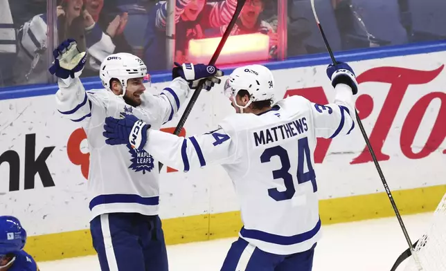 Toronto Maple Leafs center Auston Matthews (34) celebrates his goal with left wing Scott Laughton (24) during the third period of an NHL hockey game against the Buffalo Sabres Tuesday, April 15, 2025, in Buffalo, N.Y. (AP Photo/Jeffrey T. Barnes)
