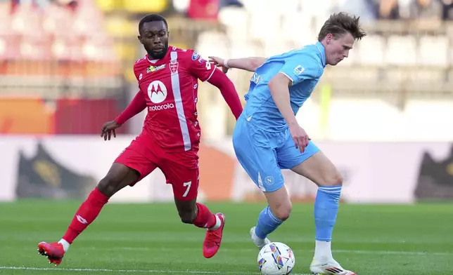 Napoli's Scott McTominay, right, and Monza's Jean-Daniel Akpa Akpro in action during the Serie A soccer match between Monza and Napoli at U-Power Stadium in Monza, Italy, Saturday April 19, 2025. (Spada/LaPresse via AP)