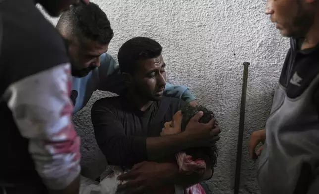 Anas El Din Hegazy holds the body of his young brother, Zain, 4, who was killed in an Israeli army airstrike on a tent in Gaza City, Monday, April 21, 2025. (AP Photo/Jehad Alshrafi)