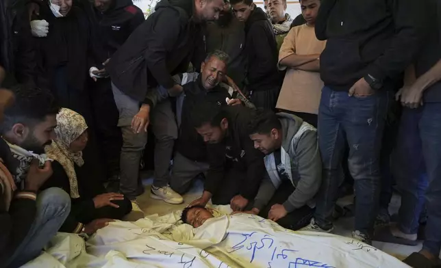 Mourners grieve over the body of Palestinian child Mohammad Abu Nada, killed in an Israeli army airstrike, during his funeral in Khan Younis, southern Gaza Strip, on Saturday, April 19, 2025. (AP Photo/Abdel Kareem Hana)