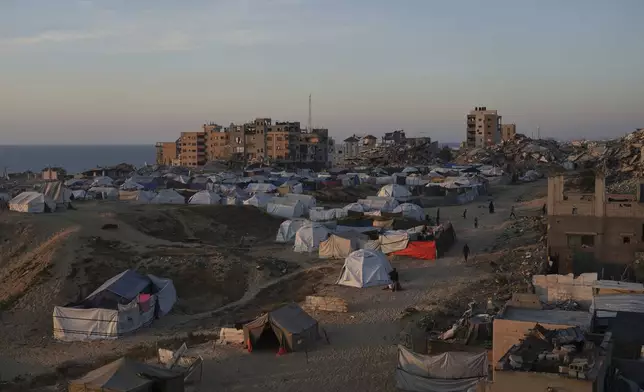 Palestinians displaced by the Israeli air and ground offensive on the Gaza Strip walk in a makeshift tent camp in Gaza City, Saturday, April 19, 2025. (AP Photo/Jehad Alshrafi)