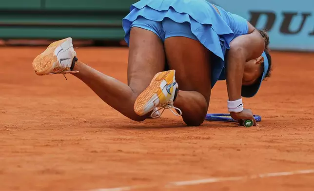 Naomi Osaka, of Japan, falls during her match against Lucia Bronzetti, of Italy, at the Madrid Open tennis tournament in Madrid, Spain, Tuesday, April 22, 2025. (AP Photo/Manu Fernandez)