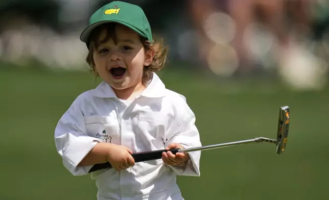 Max Homa's son, Cam Homa, holds his club on the green on the seventh hole during par-3 contest at the Masters golf tournament, Wednesday, April 9, 2025, in Augusta, Ga. (AP Photo/Julia Demaree Nikhinson)