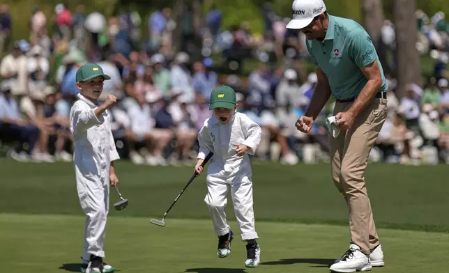 Keegan Bradley celebrates with sons Cooper, 4, and Logan, 7, left, on the seventh hole during the par-3 contest at the Masters golf tournament, Wednesday, April 9, 2025, in Augusta, Ga. (AP Photo/Julia Demaree Nikhinson)