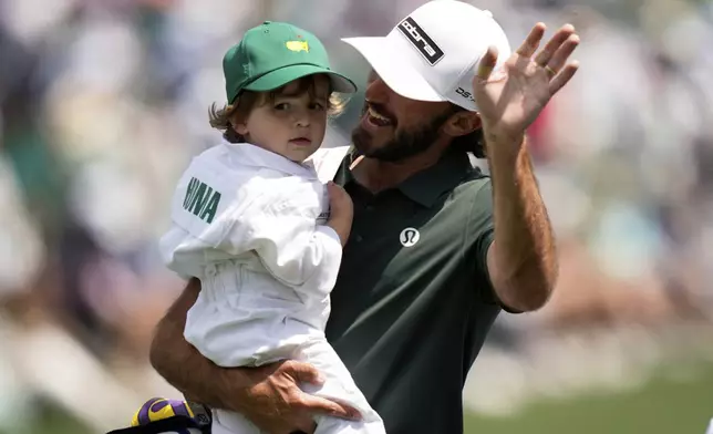 Max Homa and his son, Cam Homa, interact on the green on the seventh hole during par-3 contest at the Masters golf tournament, Wednesday, April 9, 2025, in Augusta, Ga. (AP Photo/Julia Demaree Nikhinson)